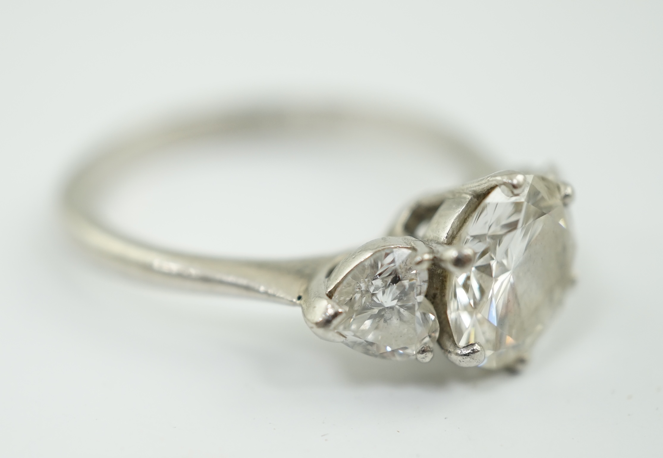 A modern Boodles & Dunthorne platinum and single stone diamond ring, with two stone heart shaped diamond set shoulders